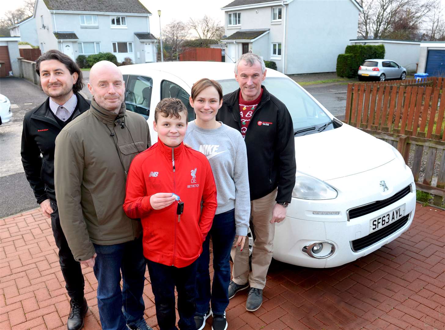 Paul, Aiden and Sarah MacLennan get the keys to the car from Inverness Taxis' Wojciech Kobialka (left) and Gavin Johnston.