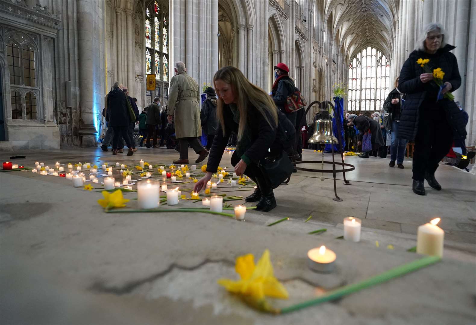 People take part in a blue and yellow themed vigil of prayer, reflection and action for the people of Ukraine at Winchester Cathedral (Steve Parsons/PA)