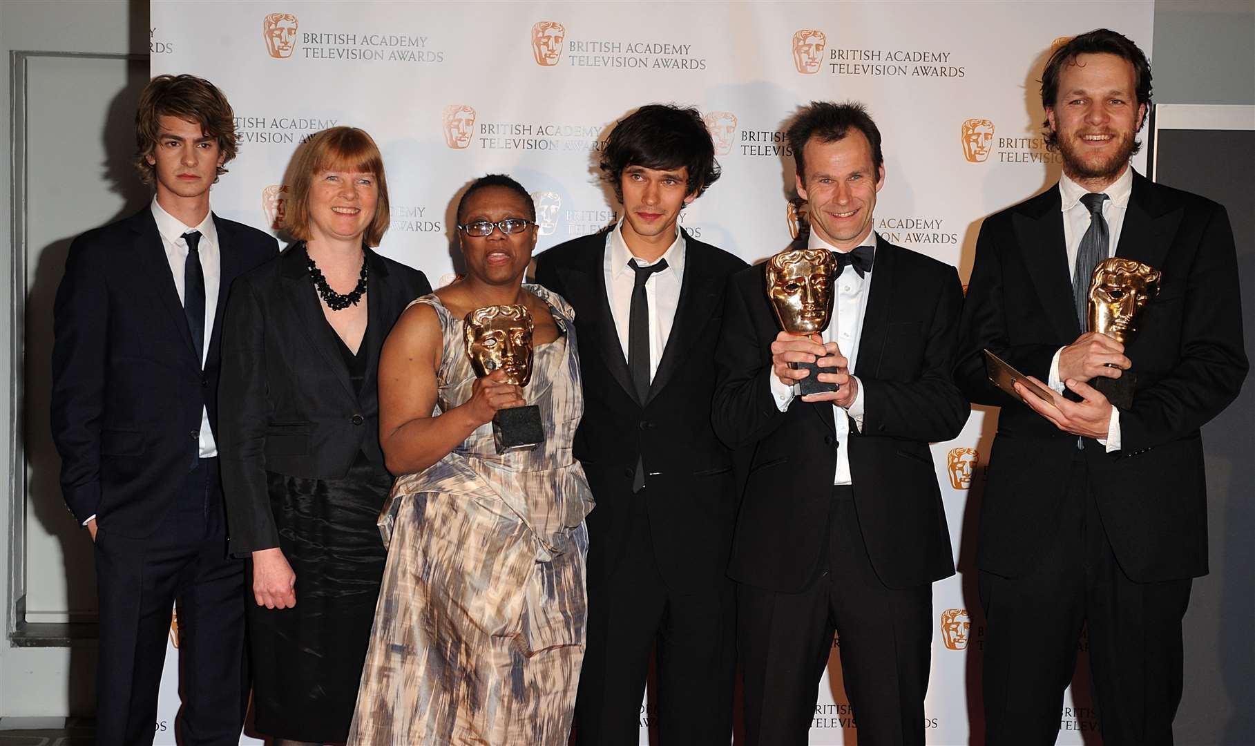 Pier Wilkie, Otto Bathurst and Peter Moffat pose with Ben Whishaw, centre, and presenter Andrew Garfield, far left, after Criminal Justice wins the award for Bafta drama serial award (Ian West/PA)