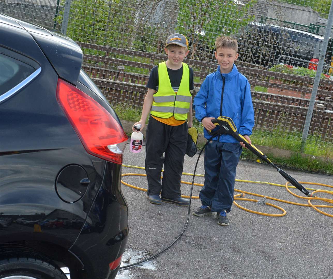 Innis Leslie and Ryan Fraser get busy clean cars to raise funds. Pictures: Gary Anthony