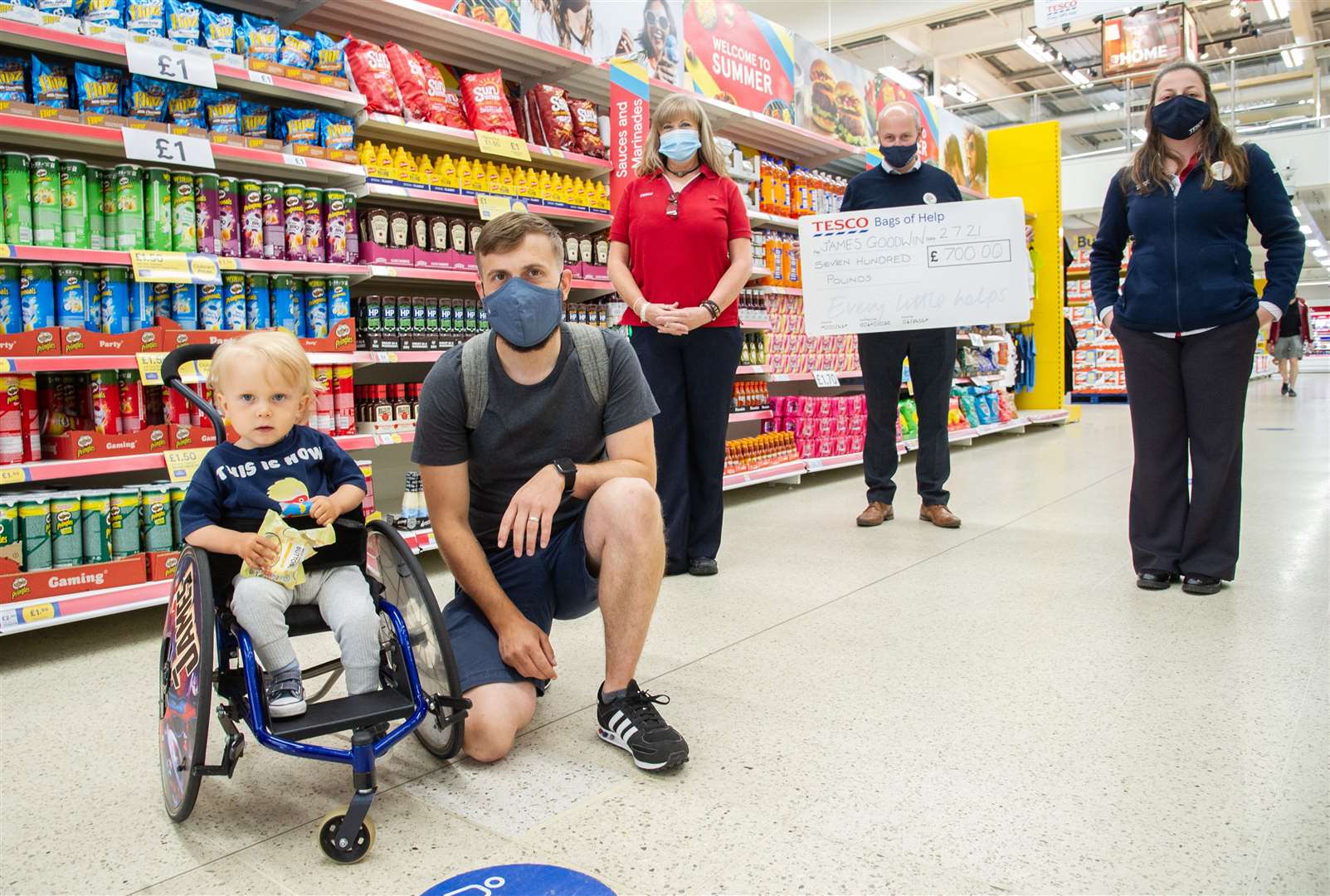 Tesco Elgin staff members Tracy Gourlay (community champion), Stephen McEwan (store manager) and Susana Simoes present £700 to James and his father Carl.Picture: Daniel Forsyth