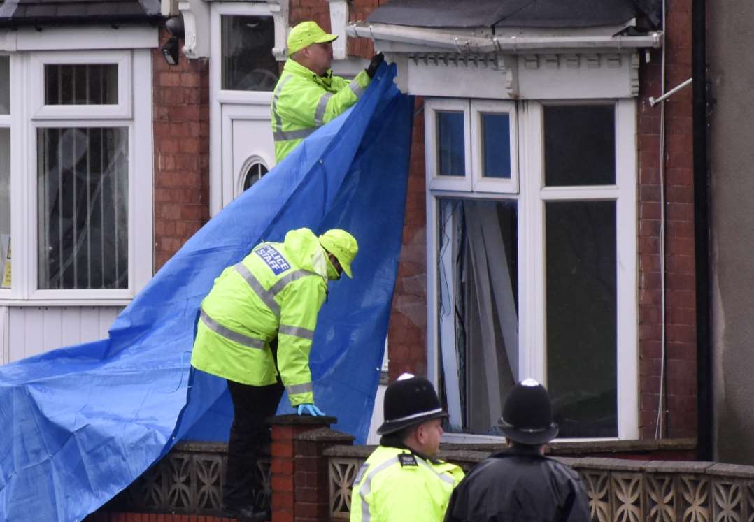 Police staff cover up a broken window after the cannabis factory ‘raid’ (Matthew Cooper/PA)