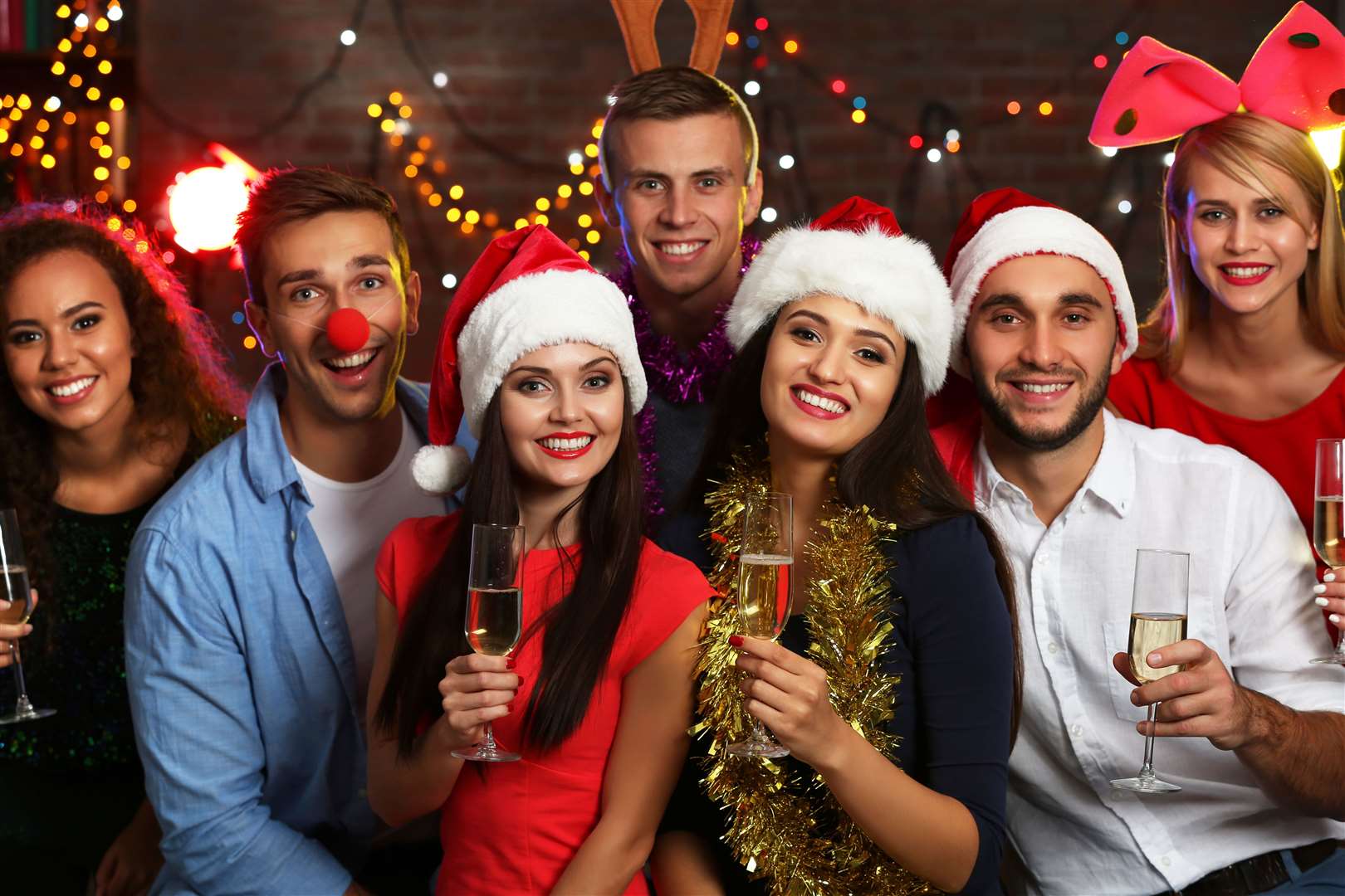 Young people with glasses of champagne at Christmas party.