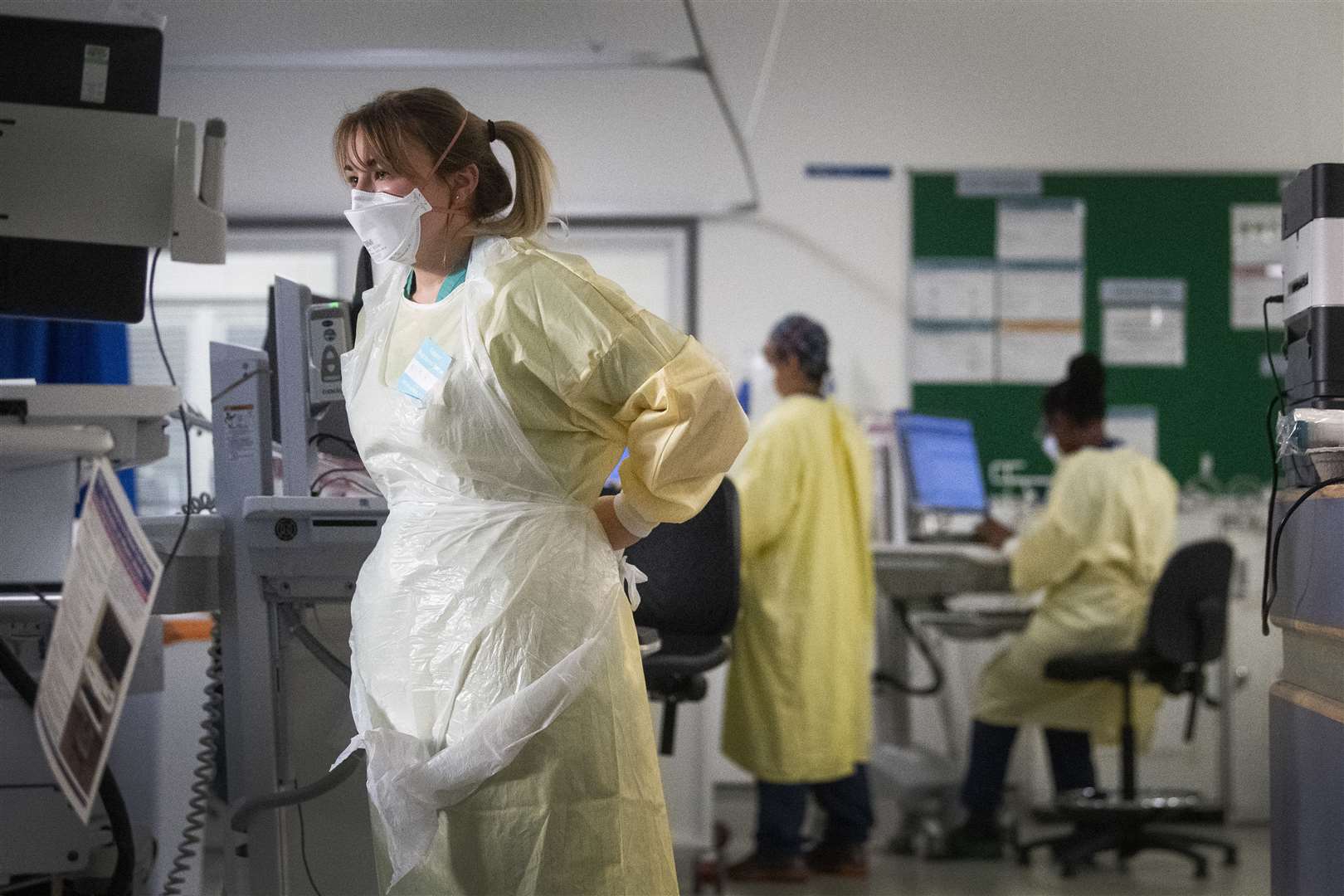 A nurse adjusts her PPE in the Intensive Care Unit (Victoria Jones/PA)