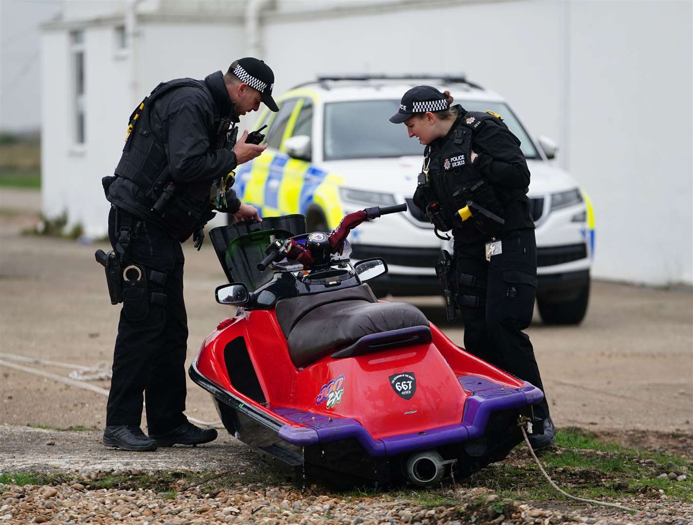 A jet ski thought to have been used in a migrant crossing is inspected by police after being brought in to Dungeness, Kent (Gareth Fuller/PA)