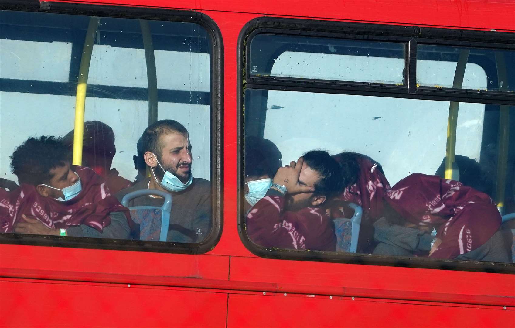 A group of people thought to be migrants wait on a holding bus after being brought in to Dover, Kent (Gareth Fuller/PA)