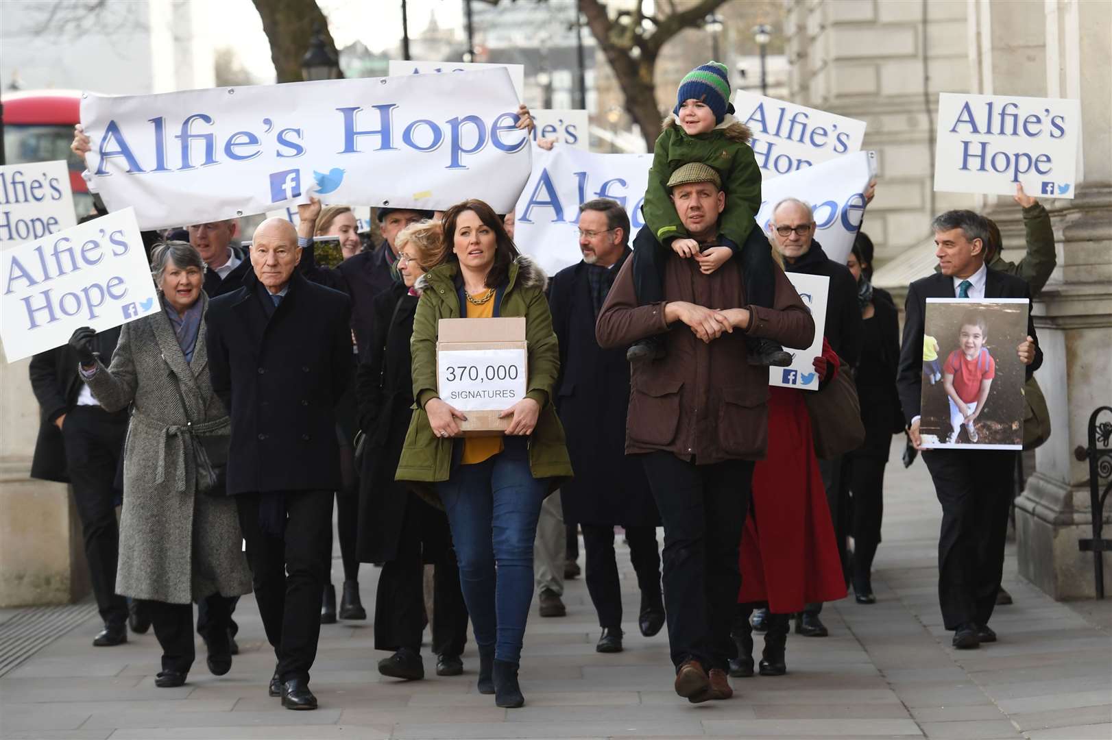 Alfie Dingley, his parents Drew Dingley and Hannah Deacon walk with actor Sir Patrick Stewartm who backed their campaign (Stefan Rousseau/PA)