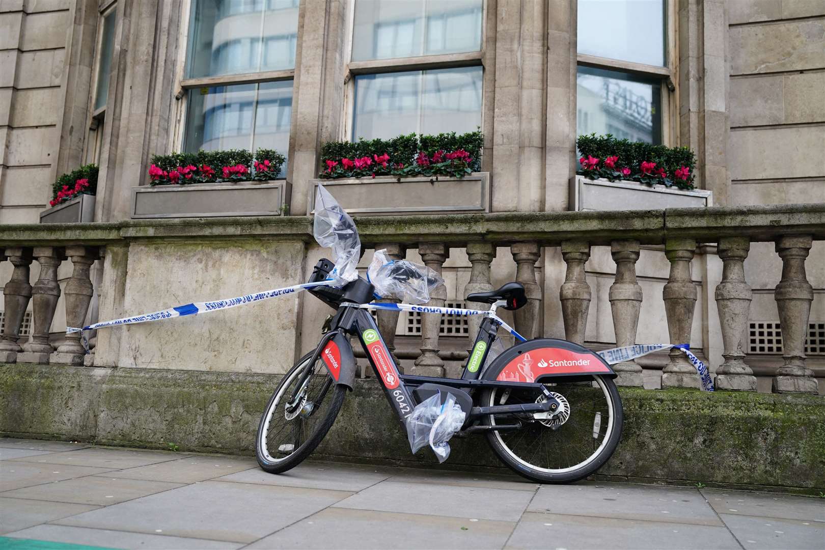 A Santander rental bike, with bags protecting potential evidence, on the road near the scene (Jordan Pettitt/PA)