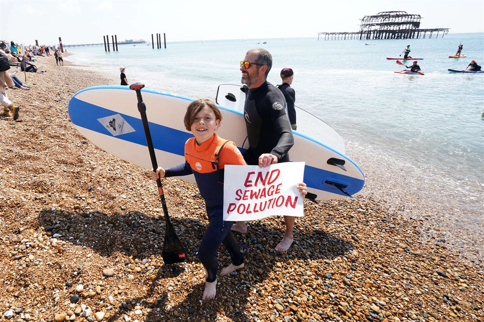 A young person holds up a placard as Surfers Against Sewage hold a protest in Brighton (Gareth Fuller/PA)