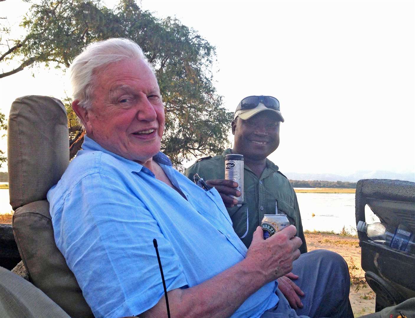 Safari guide Henry Bundure and Sir David Attenborough enjoying a sundowner last year. Picture: PA Photo/Henry Bundure