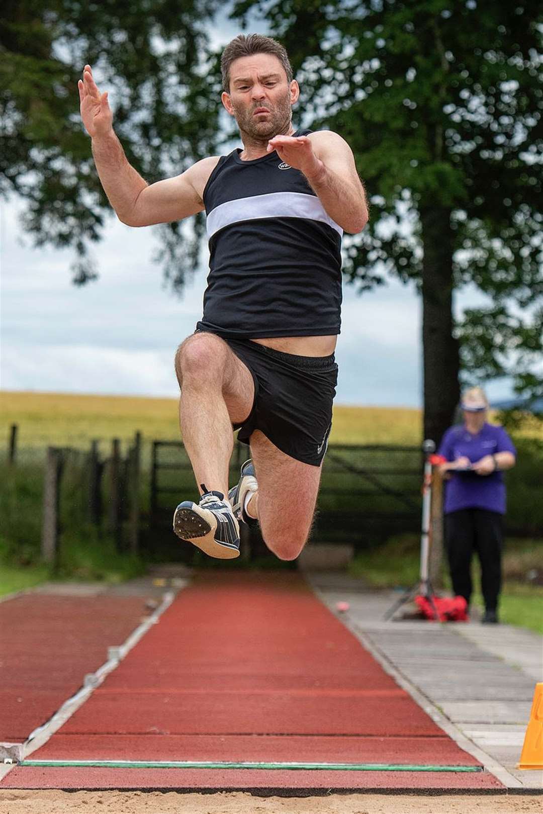 Andrew Whittaker leaps for Elgin in the M45 age group. Phil Downie Photography