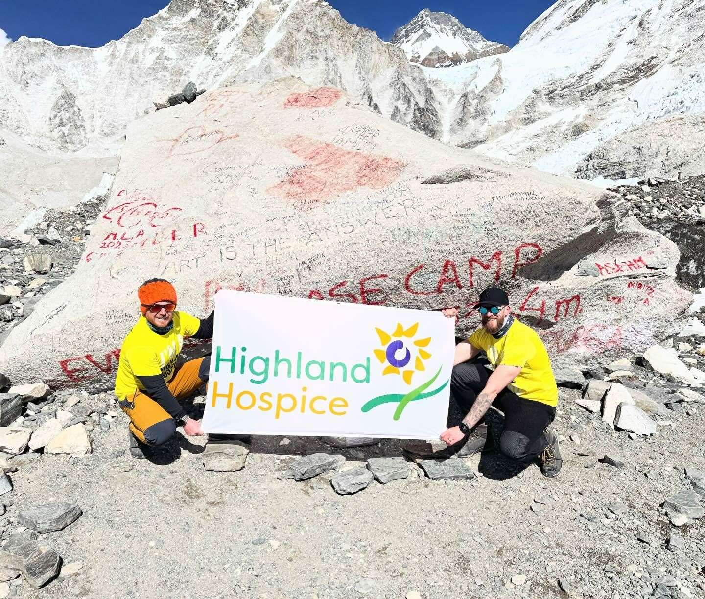 David and Ryan unfurl the Highland Hospice banner after completing their base camp mission