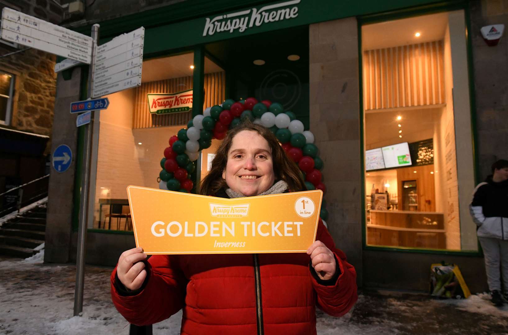Kelly Anderson from Fort Williams holding the golden ticket for being the first customer of the new shop.