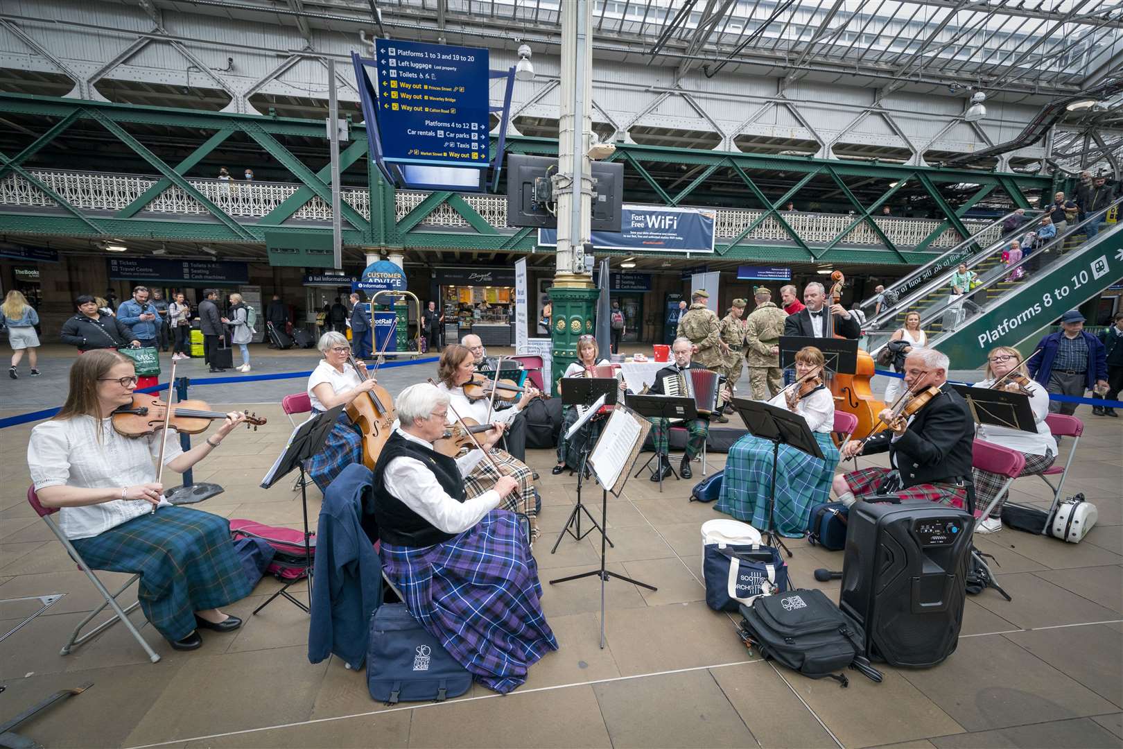 Members of the Scottish Fiddle Orchestra play in a pop-up performance at Edinburgh’s Waverley Station (Jane Barlow/PA)