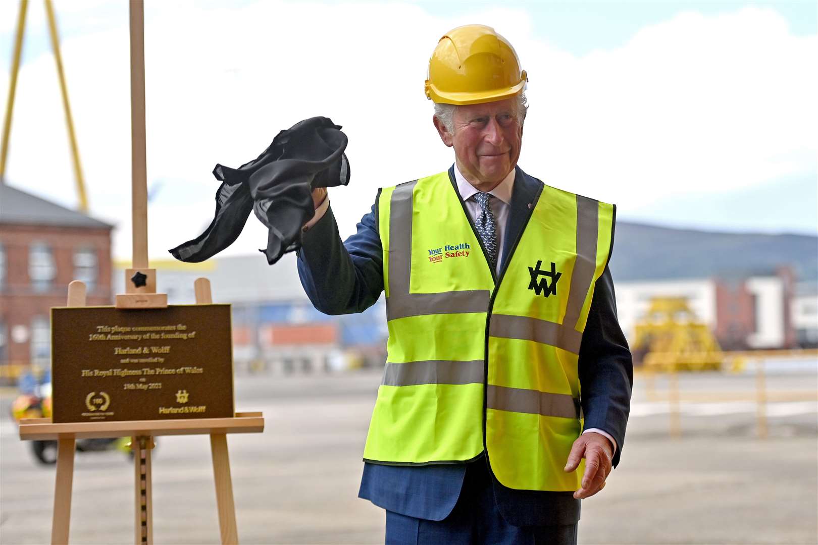 The Prince of Wales unveils a commemorative plaque during a visit to Harland & Wolff at Queen’s Island, Belfast (Samir Hussein/PA)