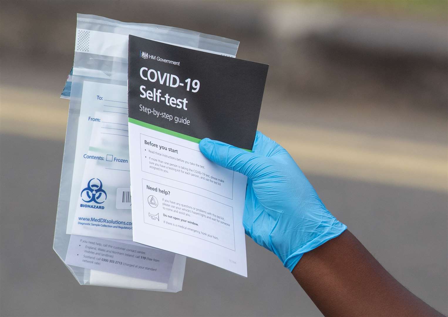 Staff hand out self-test kits at a coronavirus testing centre (Dominic Lipinski/PA)