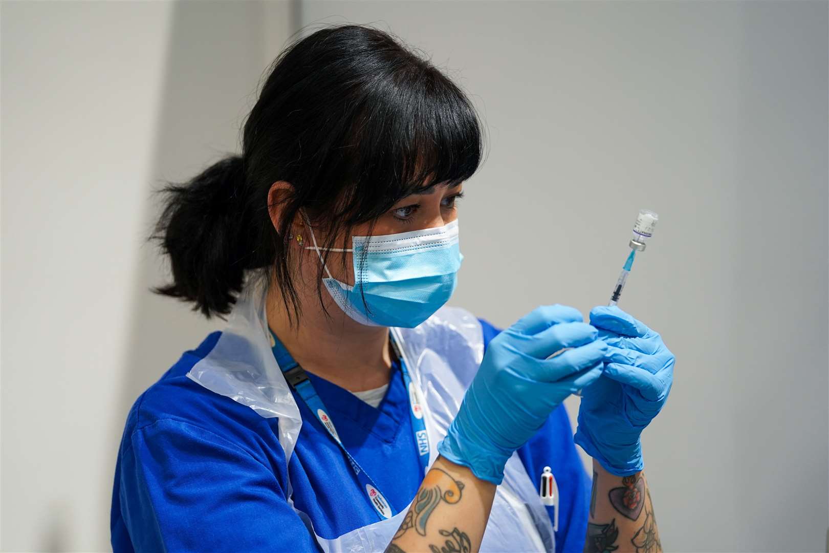 A member of staff prepares a Covid-19 Pfizer jab at a pop-up vaccination centre at Westfield Stratford City (Kirsty O’Connor/PA)