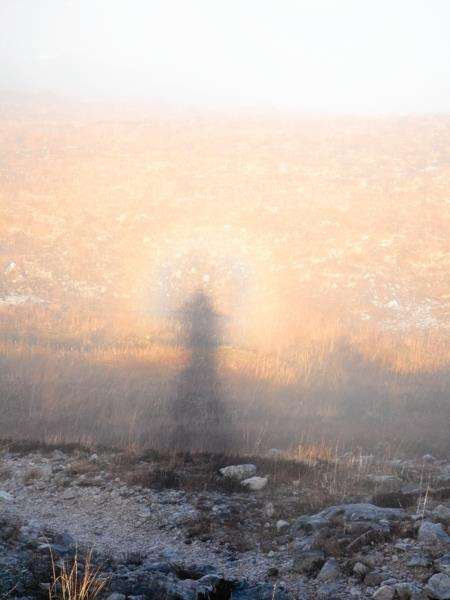 A Brocken spectre forms on mist below Conservation Cairn on the Torridon mountain path.