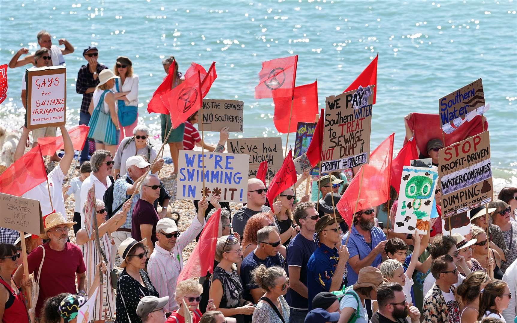 Members of the public and protesters from Hastings and St Leonards Clean Water Action, protest against raw sewage release incidents on the beach in St Leonards, Sussex (Gareth Fuller/PA)
