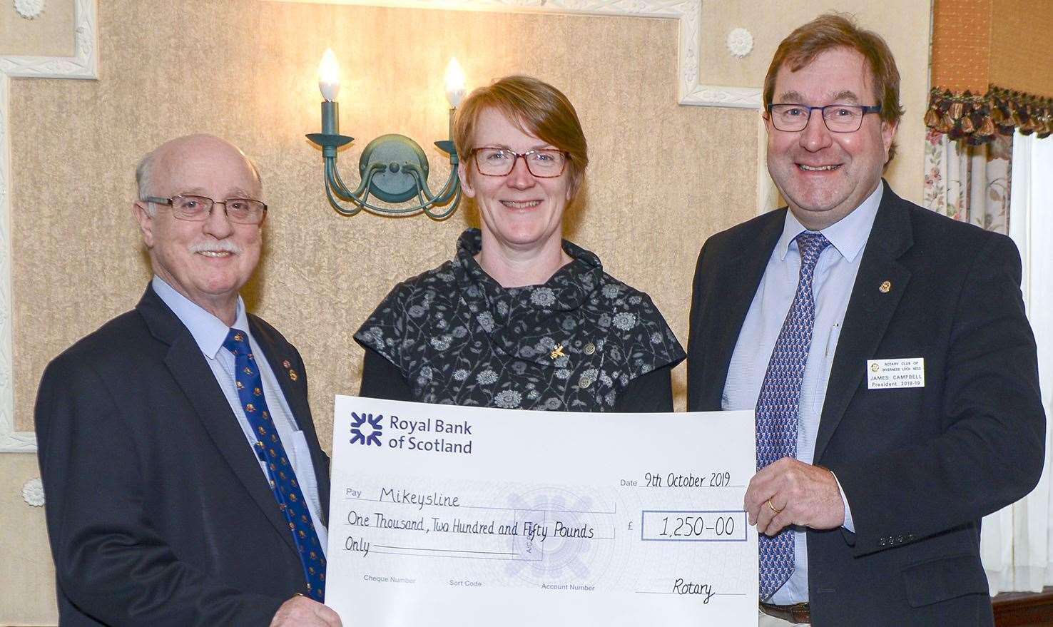 Mikeysline’s Donna Smith (centre) with Rotary Club members Nicol Manson and James Campbell.