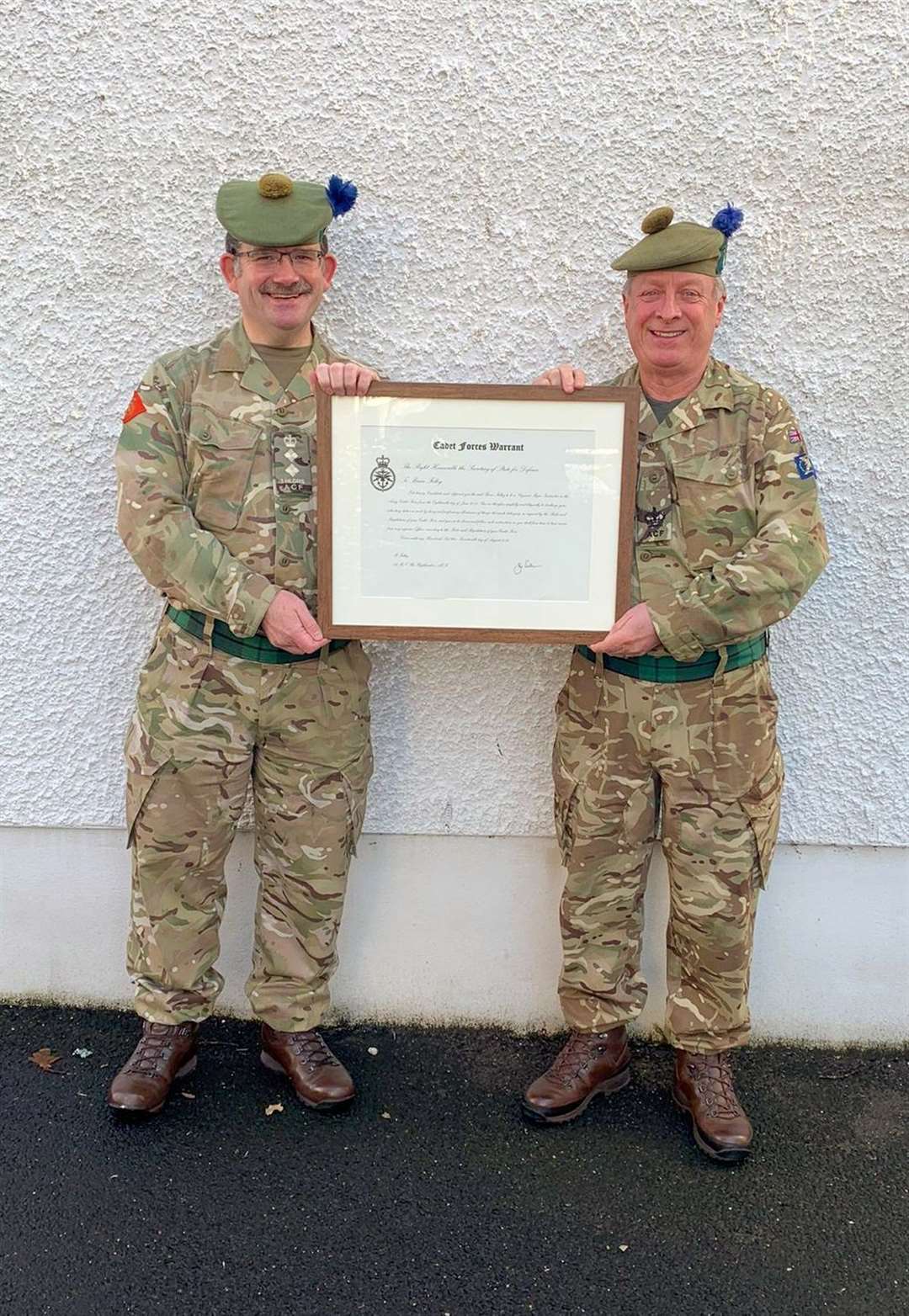 SMI Folley (right) receiving the Cadet Force Warrant from the Battalion's Commandant Col MacDonald.