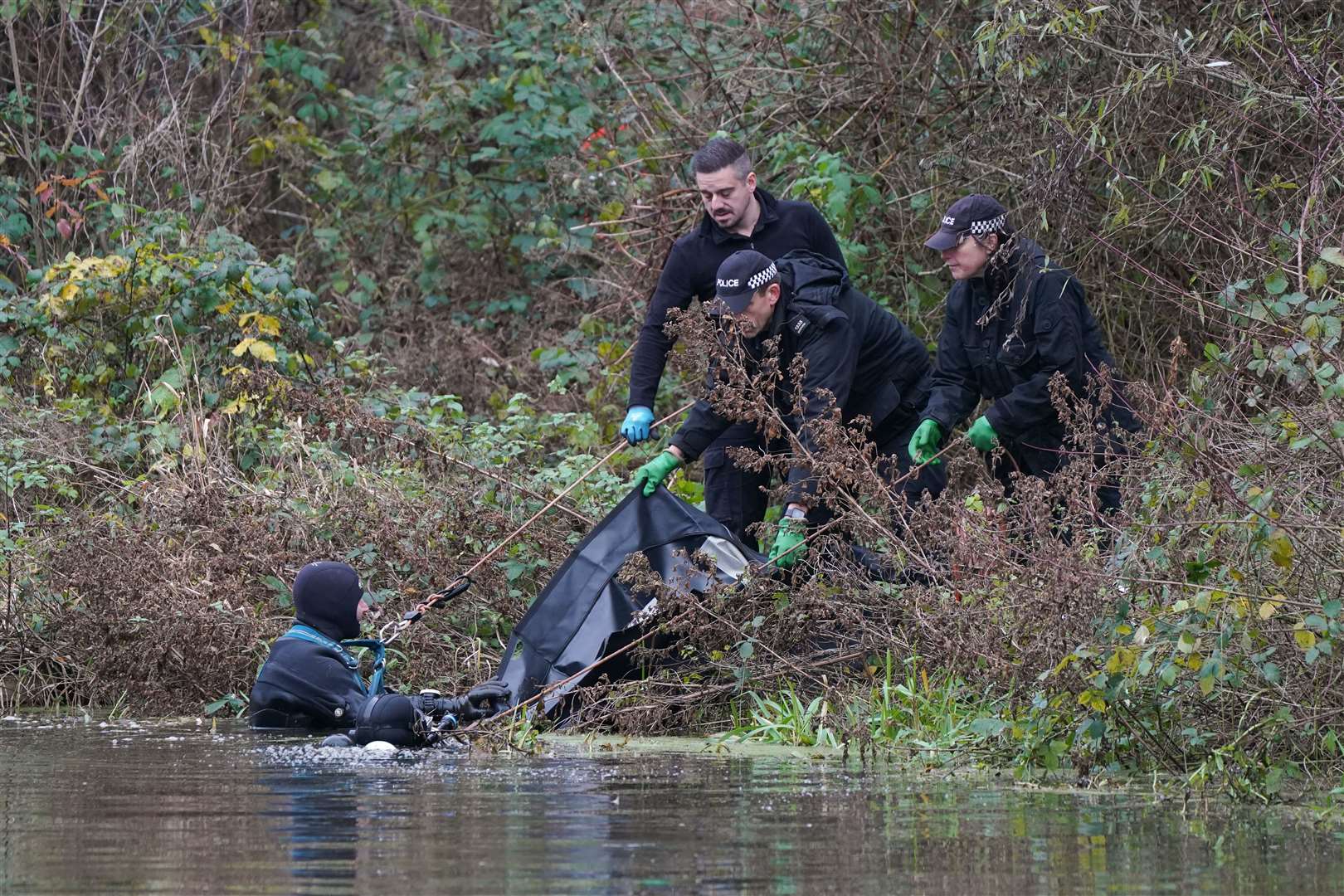 Police search teams pull a black bag from the River Wensum during the search for the missing mother-of-three (Joe Giddens/PA)