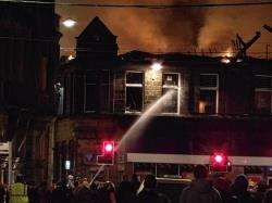 Firefighters spraying water into the upper floor of the building during last night's fire.