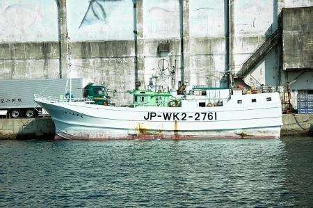 The sturdy tuna fishing boats, by the stark processing plant at Katsuura
