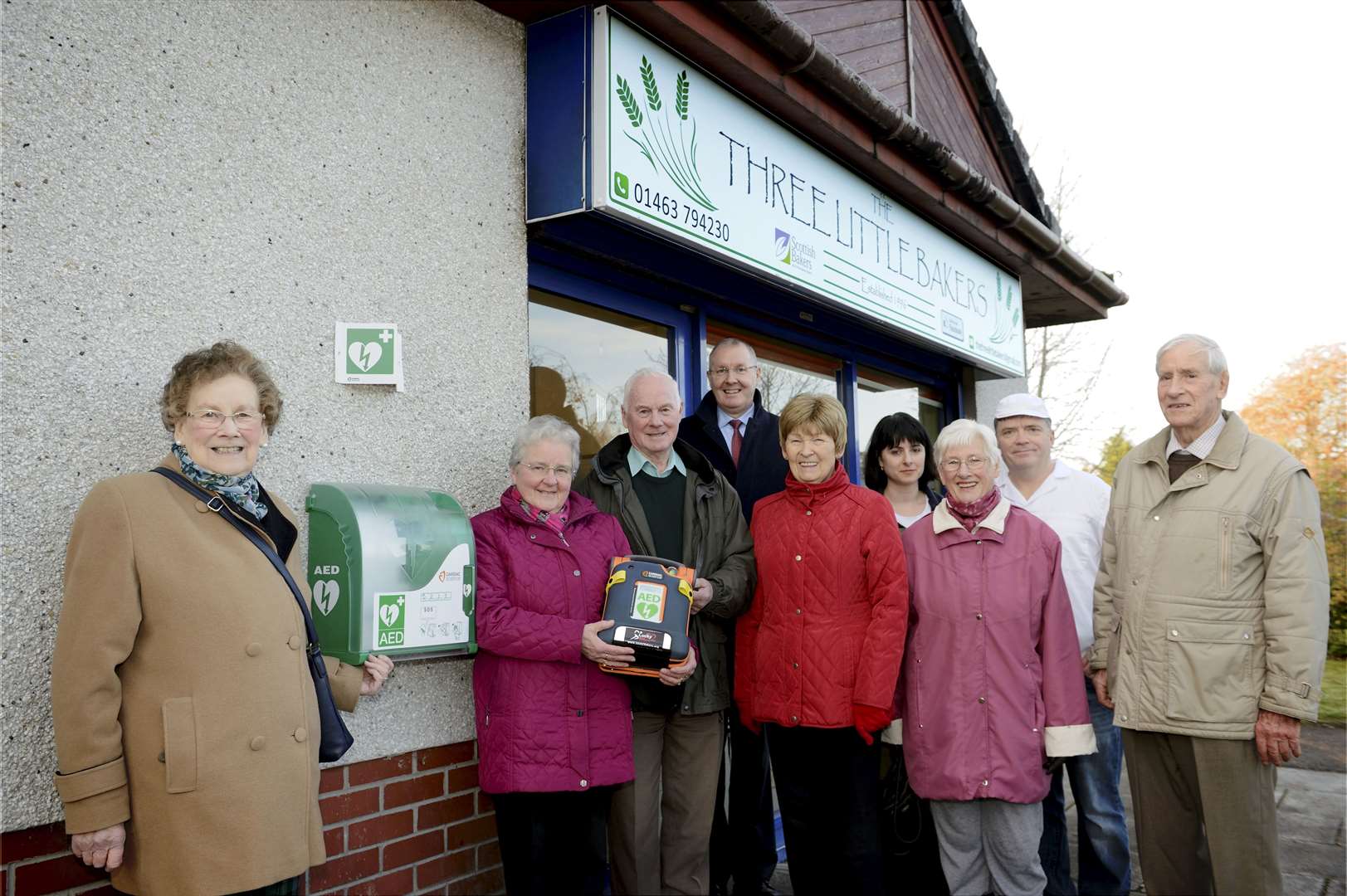 Marlene and Hugh Munro with one of the defibrillators bought using donations, surrounded by people from the community.