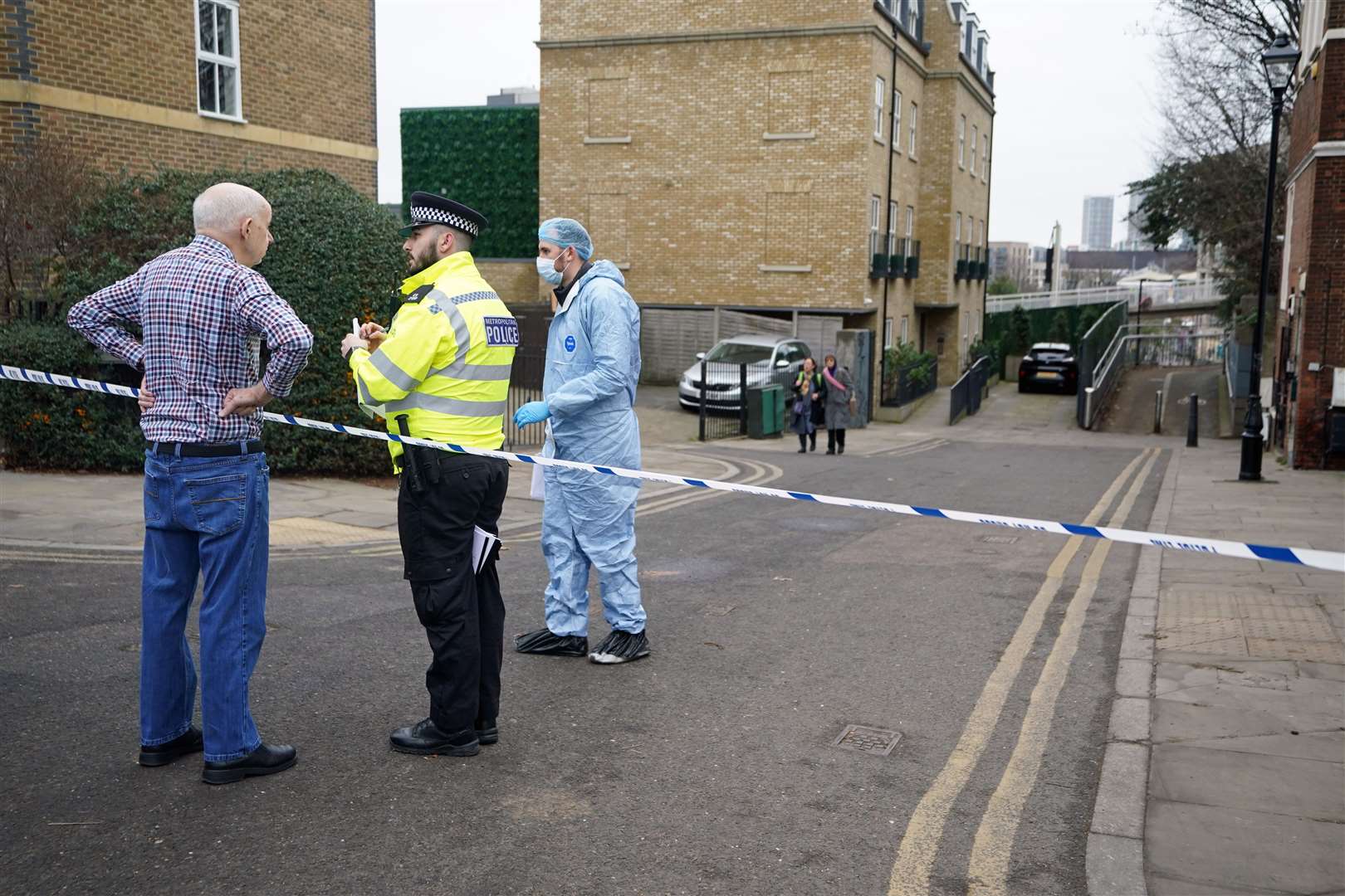 Police talk to residents at the scene (James Manning/PA)
