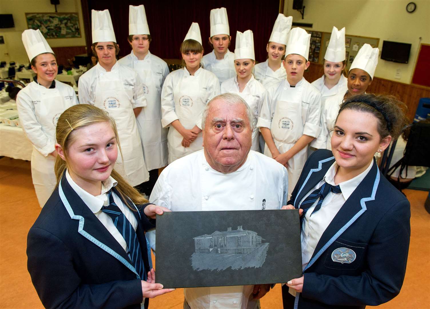 Albert Roux being presented with a plaque by Charleston Academy pupils Amy Anderson and Rachael Armitage at a gala dinner in 2012.