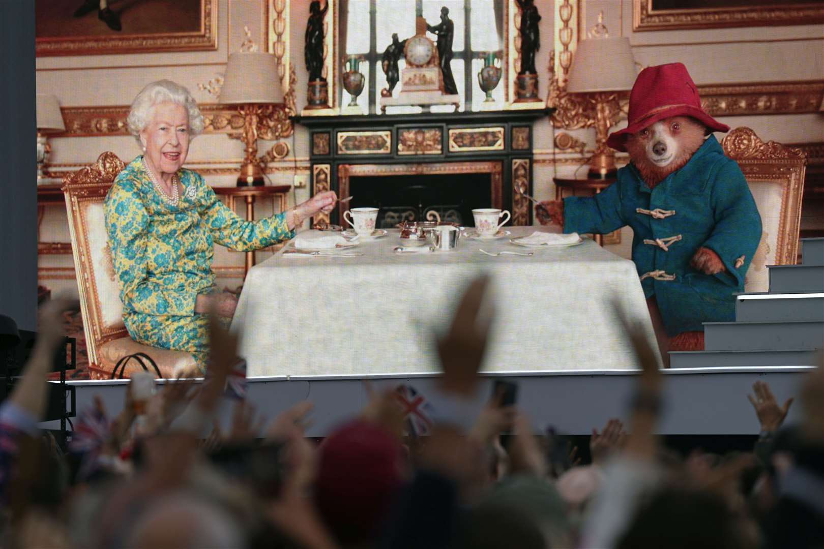 The crowd watching a film of the Queen having tea with Paddington Bear on a big screen during the Platinum Party at the Palace (Victoria Jones/PA)
