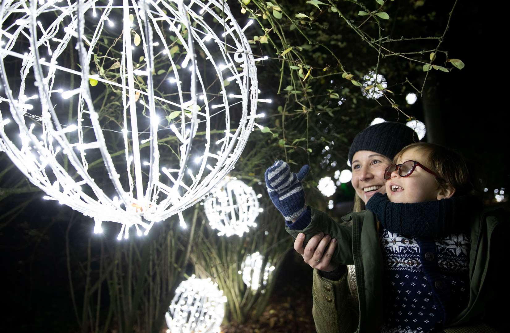 Maria Del Pilar Mira Ponton and her son Alfred Alejandro Dudely-Mira look at a lantern hanging from a tree (Andrew Matthews/PA)