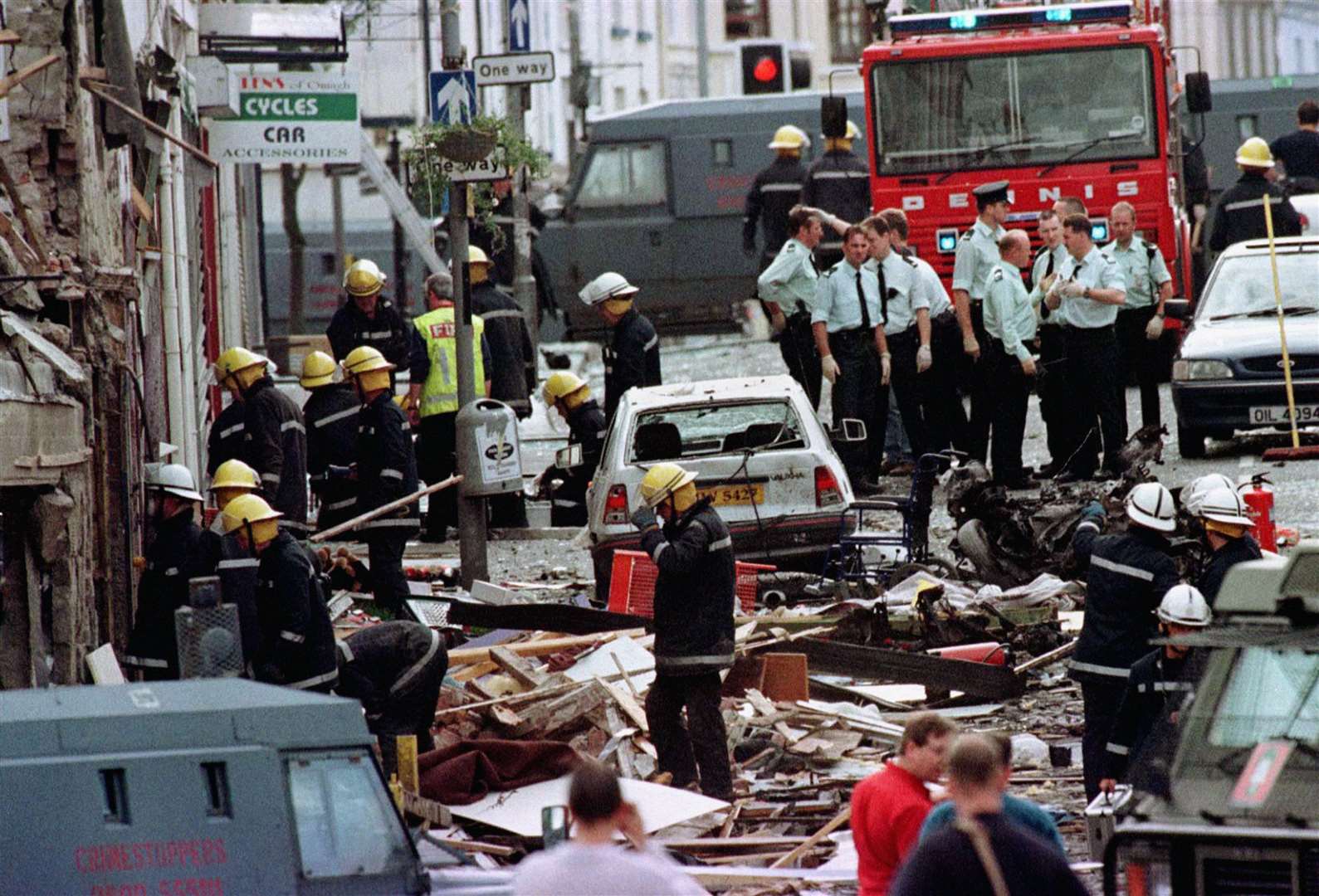 Police officers and firefighters inspect the damage caused by a bomb in Omagh (Paul McErlane/PA)