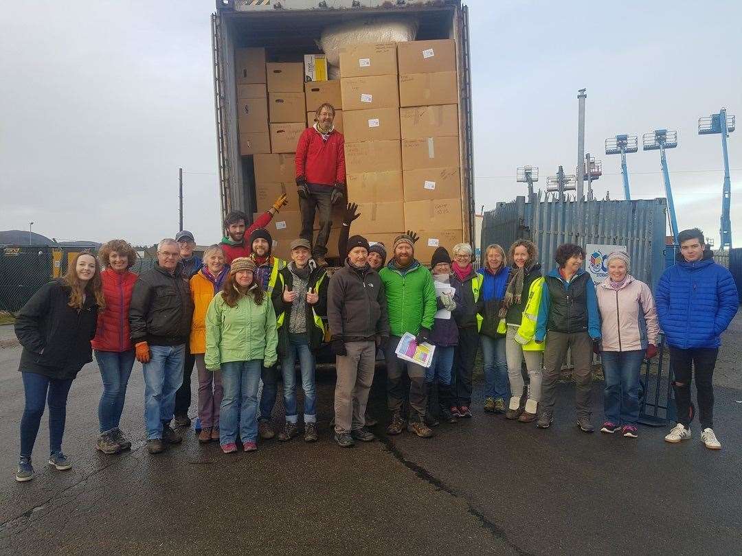 The group of volunteers packing a lorry of goods.