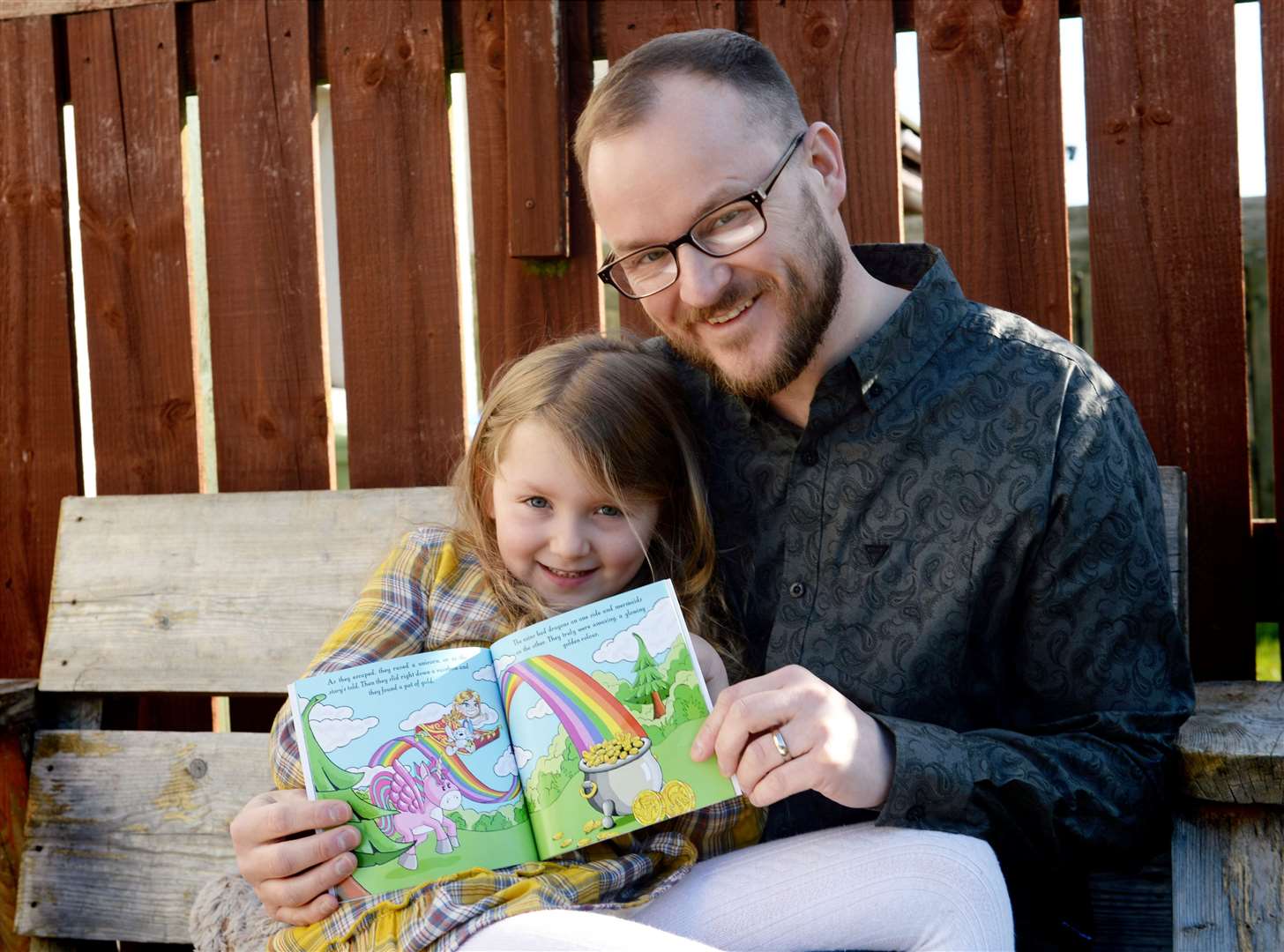 Brian D Morrison reading his book to his daughter Myla. Picture: James Mackenzie