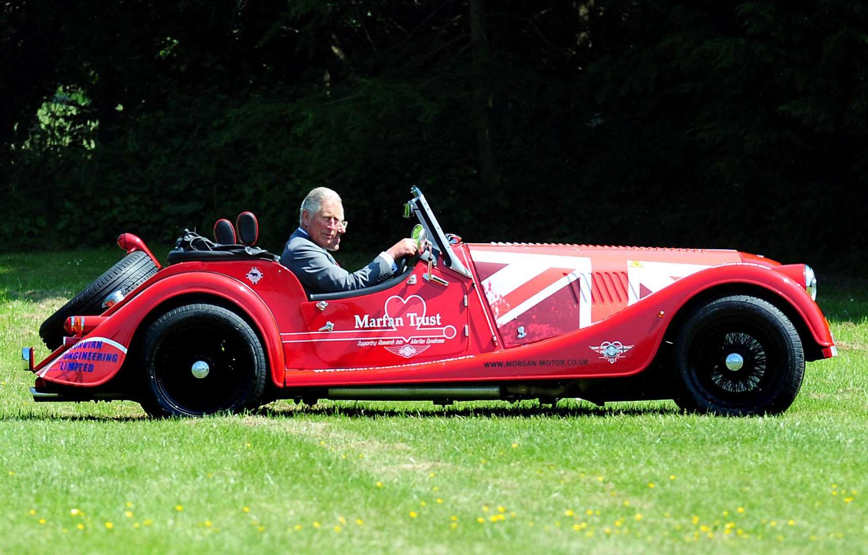 The King in a Morgan Plus 4 car during a visit to Morgan Motor Company in Malvern, Worcestershire (PA)