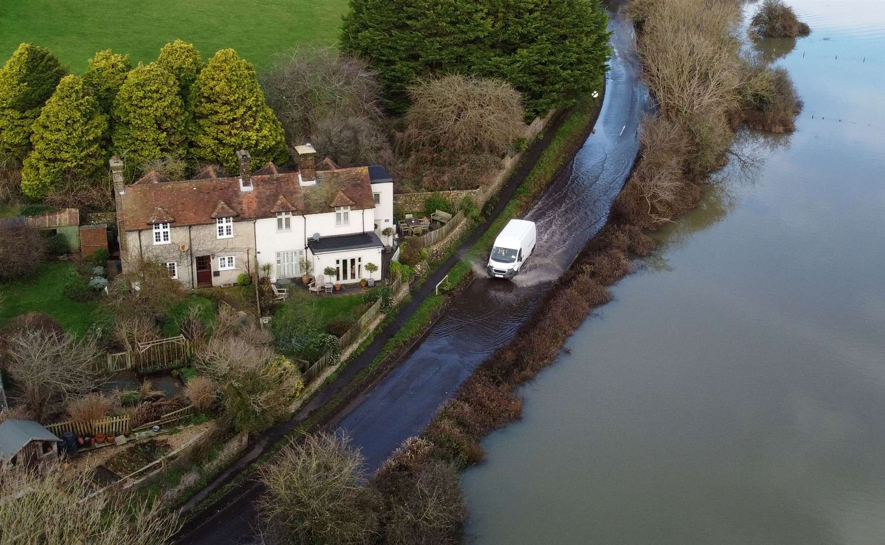 A van passes through floodwater from the Cuckmere River in Alfriston, East Sussex (Gareth Fuller/PA)
