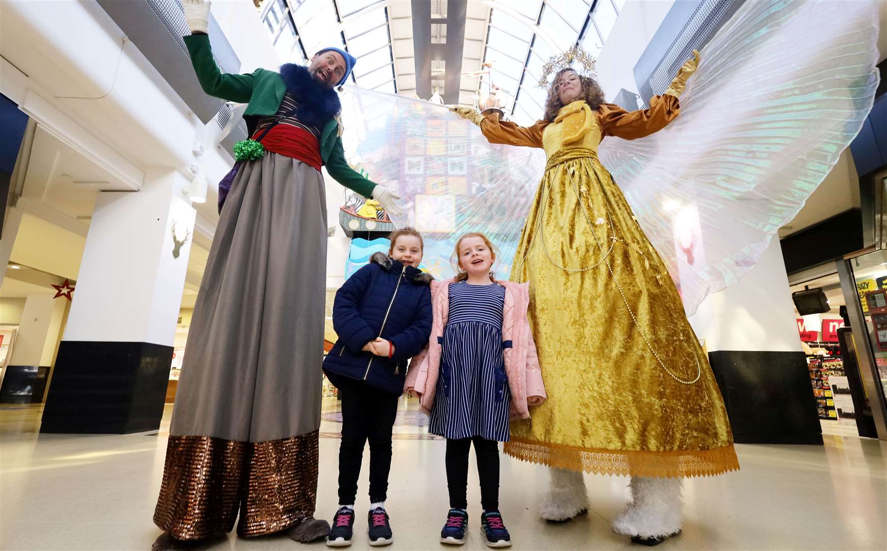 Grace and Aria Ross with the Tall Elf and Christmas Tree Fairy from Fly Agaric Performing Arts. Picture: James Mackenzie