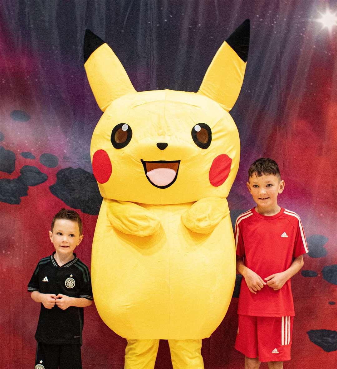 Kaleb and Kai Cameron from Inver pose for a pic with Pikachu. Photo: Niall Harkiss