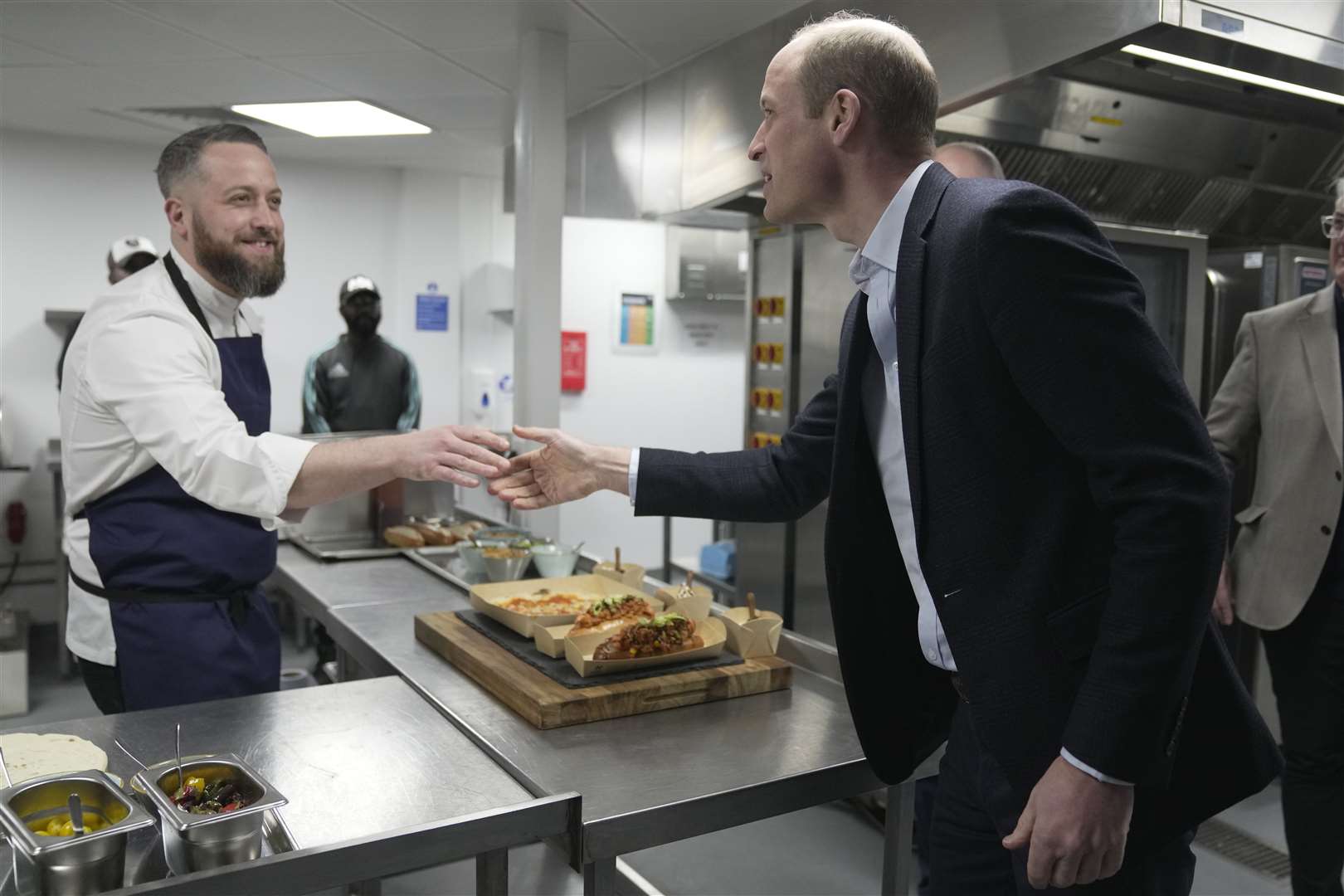 The Prince of Wales (right) shakes hands with a chef who has prepared food in seaweed-based food containers made by Earthshot 2022 winner Notpla, during a visit to the Kia Oval Cricket Ground (Kin Cheung/PA)