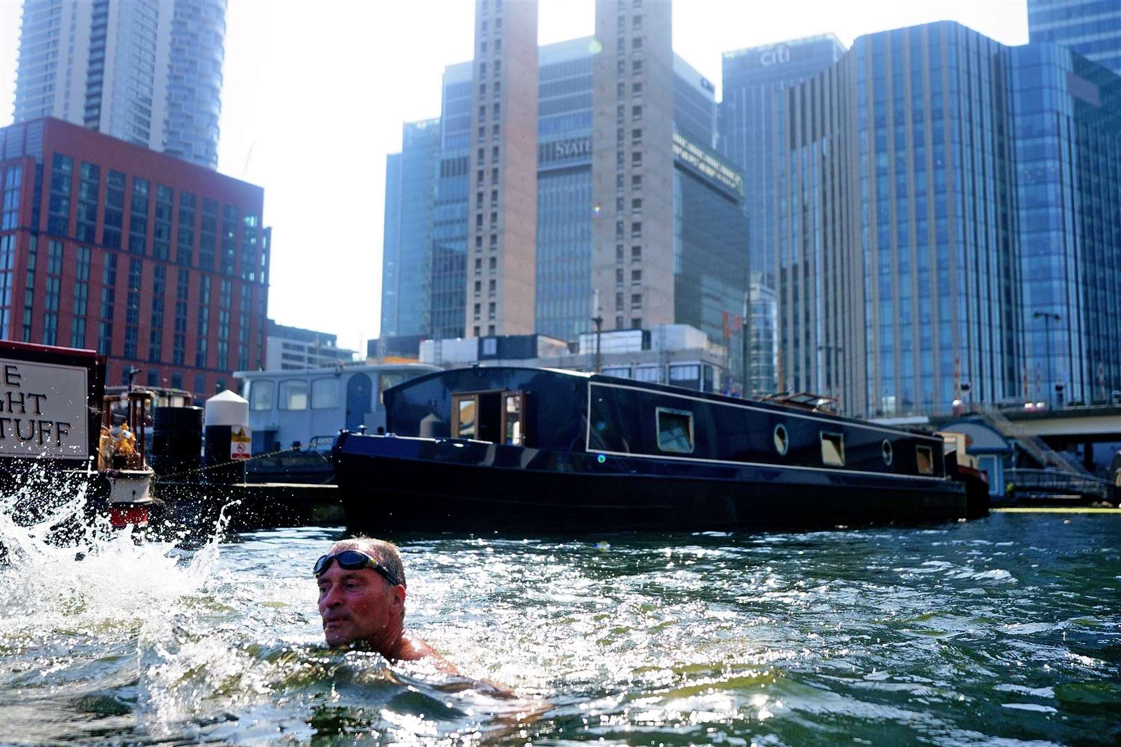 A swimmer in water in the Canary Wharf docklands in east London (Victoria Jones/PA)