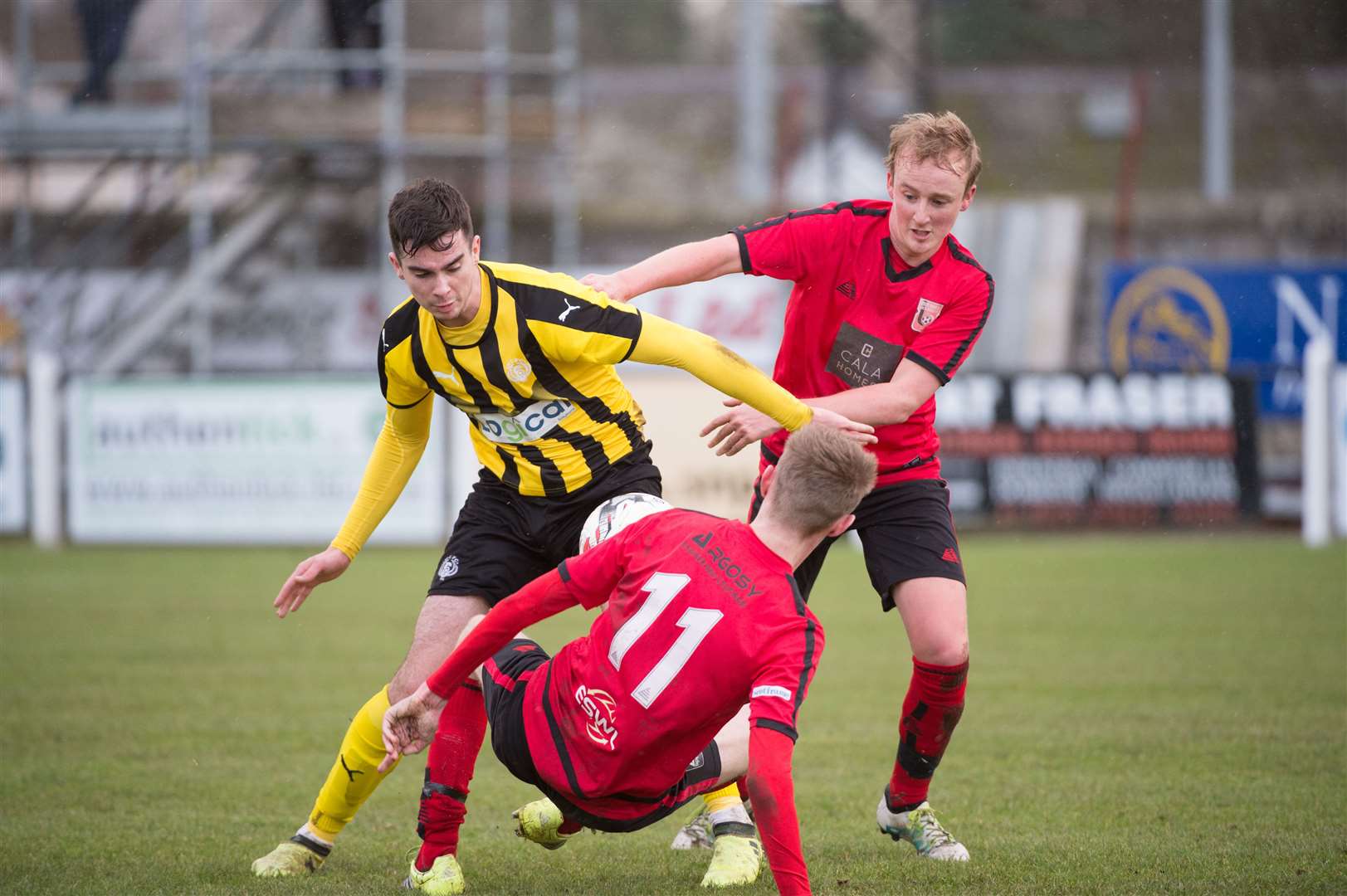 Breedon Highland League - Nairn County v Inverurie Locos, Station Park, Nairn...Nairn's Tom MacLennan fights hard to keep possession from Locos Jamie Michie and Andrew Watt (11)...Picture: Callum Mackay. Image No. 043182.
