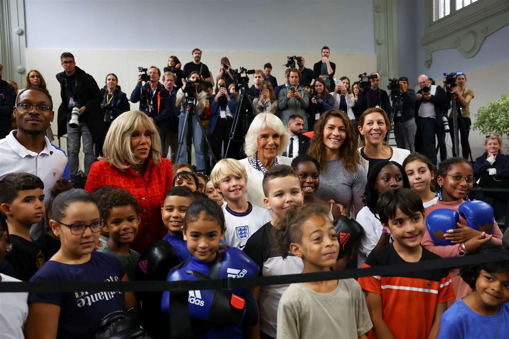 The Queen and Brigitte Macron posed with young athletes (Hannah McKay/PA)