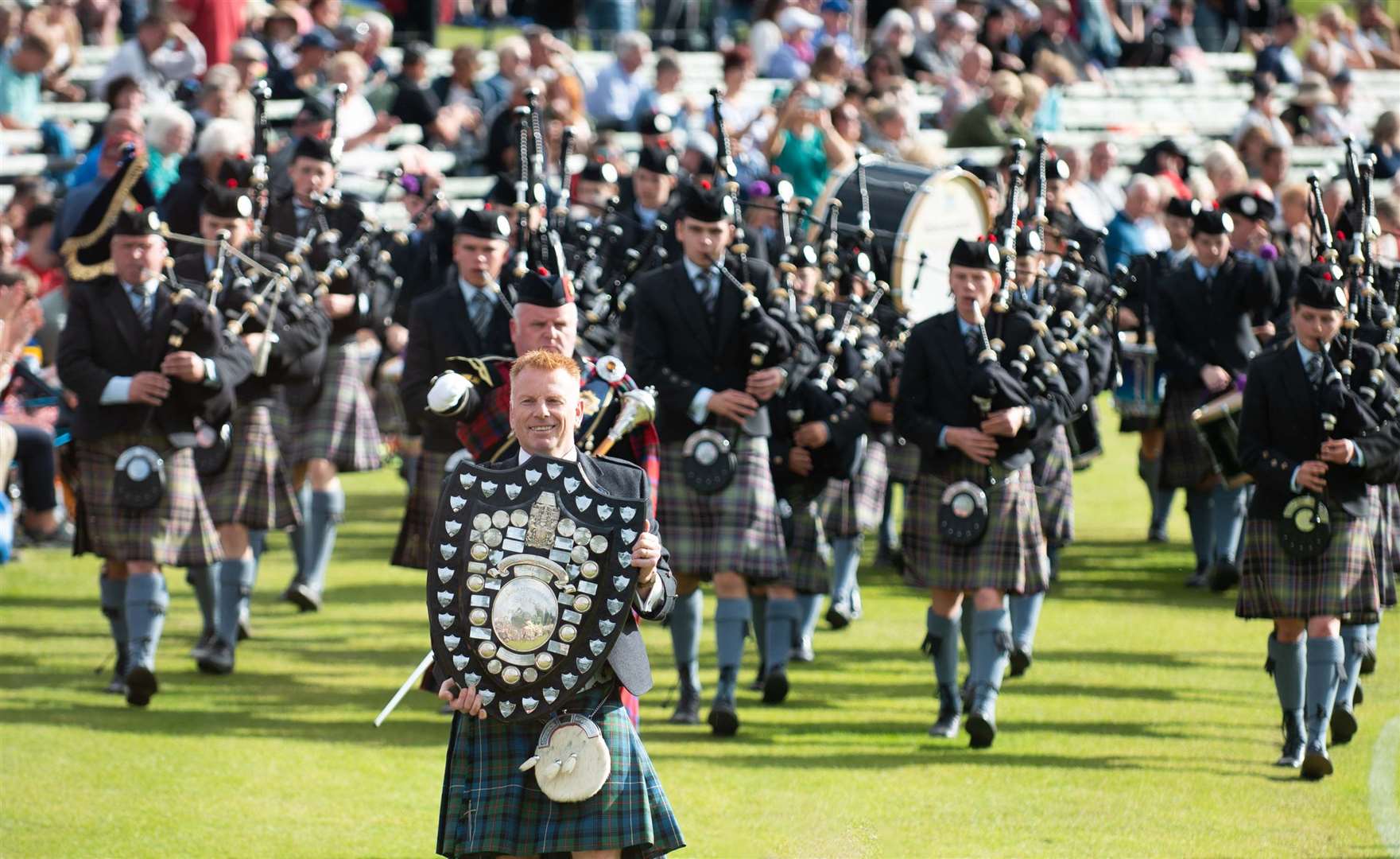 Andrew Lyall, Gordonstoun’s head of development, holds the shield as the pipe band plays (Michael Trail/PA)
