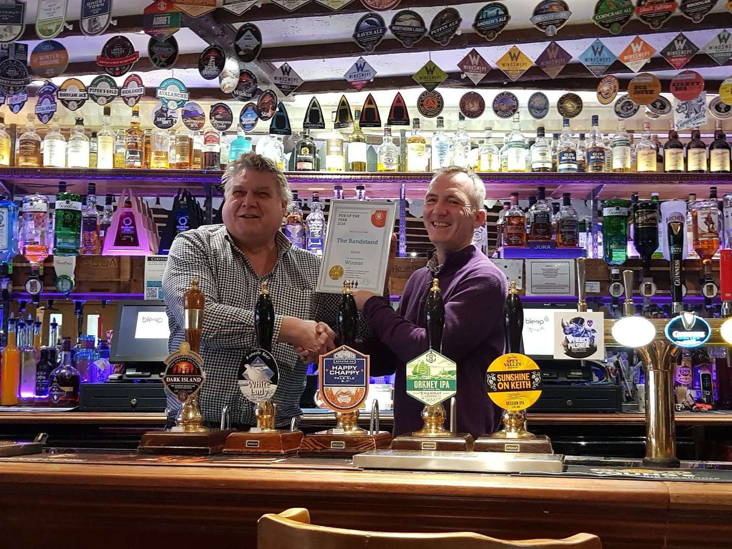 CAMRA Highlands and Western Isles branch chairman Simon Urry presents the award to Paul Geddes from the Bandstand Bar and Restaurant in Nairn.