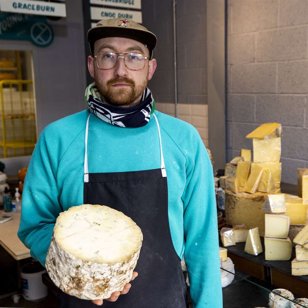 Michael Thomson, of Mike’s Fancy Cheese in Belfast, holds half a truckle of Young Buck, a raw milk blue cheese made in Newtownards, Northern Ireland (Liam McBurney/PA)